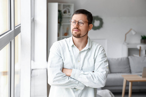 Handsome man in stylish eyeglasses at home - Фото, зображення