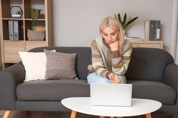 Mulher madura com laptop de vídeo conversando em casa - Foto, Imagem
