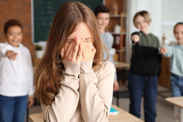Gemobbtes kleines Mädchen weint im Klassenzimmer, Nahaufnahme - Foto, Bild