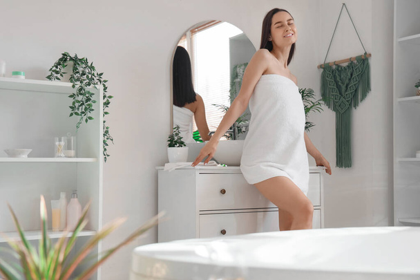 Όμορφη νεαρή γυναίκα με πετσέτα μετά το ντους στο μπάνιο - Φωτογραφία, εικόνα