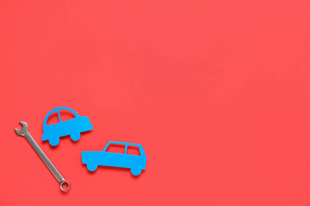 Ключ и игрушечная машина на красном фоне. Механические концепции - Фото, изображение