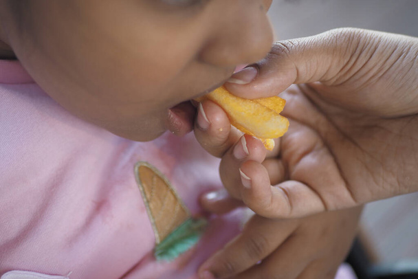  παιδί τρώει τηγανητές πατάτες από κοντά , - Φωτογραφία, εικόνα