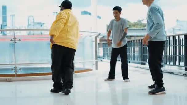 A hip-hop tinédzser csoport B-boy táncot ad elő a pláza folyosóján városi vagy égi lesöprő kilátással. Egy csoport élénk táncos show break dance és körül multikulturális barátok. Szabadtéri sport 2024. hiphop. - Felvétel, videó
