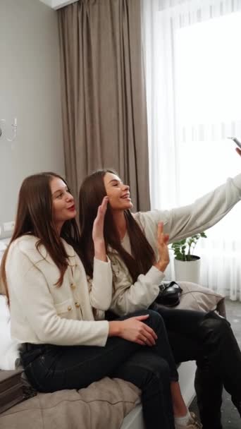 Duas jovens vão de férias. Uma mulher entra num hotel, ri-se e tira uma selfie. Vídeo vertical - Filmagem, Vídeo