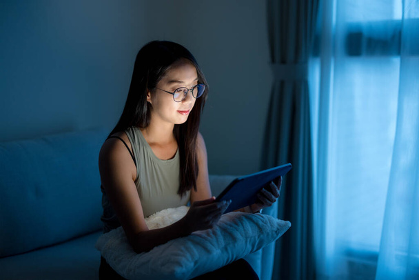 Жінка в окулярах і використання цифрового планшета ввечері вдома - Фото, зображення