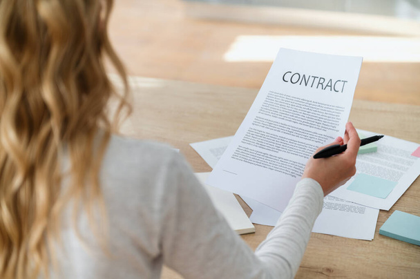 Businesswoman reading contract before signing. Making financial business deal, sale and purchase transaction. Concept of application form for mortgage, loan, buy or rent house. Important papers. - Photo, Image