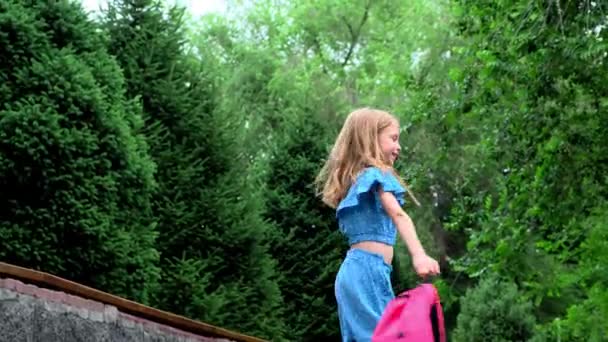 Ein 9-jähriges Mädchen mit schönem Haar ist mit einem Rucksack unterwegs. Hochwertiges 4k Filmmaterial - Filmmaterial, Video