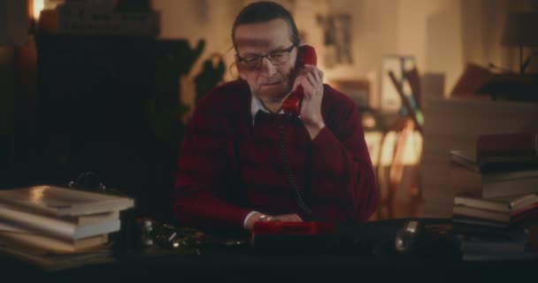 Zamyšlený starší muž v matně osvětleném domově, slavnostně přemýšlející o životní cestě v tichosti noci - Záběry, video