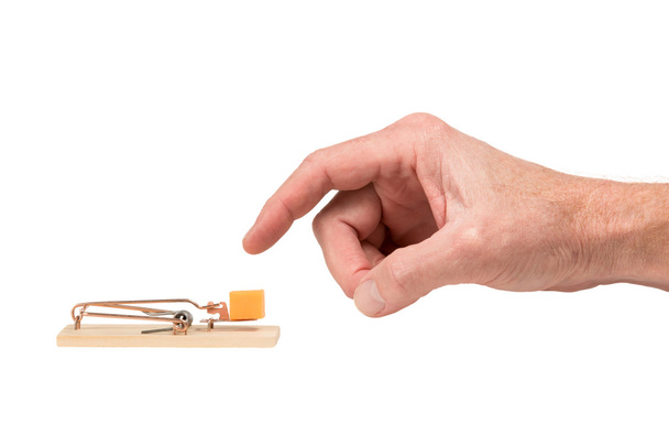 Hand Reaching for Cheese in a Mousetrap - Photo, Image