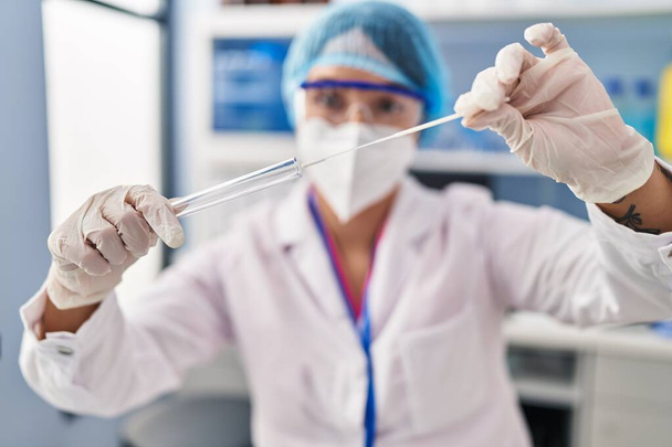 Młoda piękna latynoska kobieta naukowiec nosi maskę medyczną trzymając test antygenu w aptece - Zdjęcie, obraz