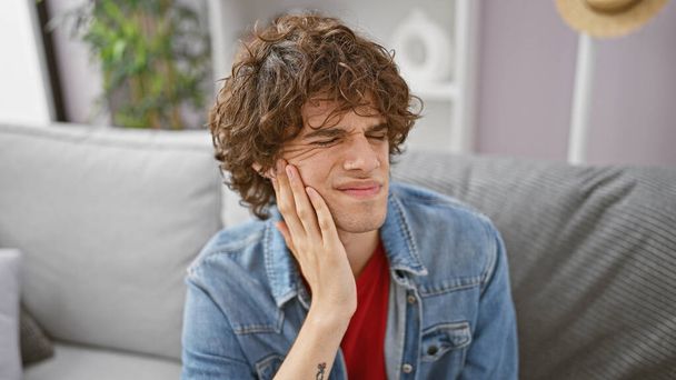 Latino mies parta kärsii hammassärky kotona, ilmaista kipua ja epämukavuutta. - Valokuva, kuva