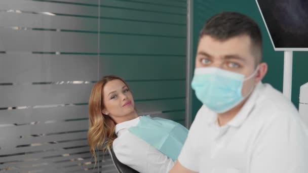 Стоматолог і пацієнт з впевненою посмішкою дивляться на камеру в стоматологічному кабінеті, висловлюючи позитивну атмосферу і довіру між ними. Високоякісні 4k кадри - Кадри, відео