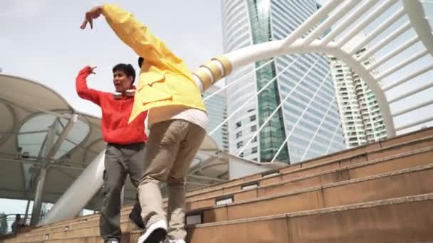 Diverse hipster groep lopen de trap op tijdens het uitvoeren van straatdans. Aantrekkelijke Aziatische danser danst samen met multiculturele vriend in de stad. Vrije stijl, levensstijl. Outdoor sport 2024. Schitterend.. - Video