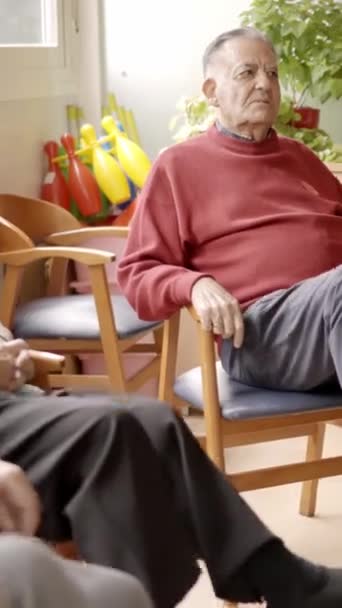 Lassított felvételen idős emberek pedáloznak, miközben egy idősek otthonában ülnek egy szobában. - Felvétel, videó