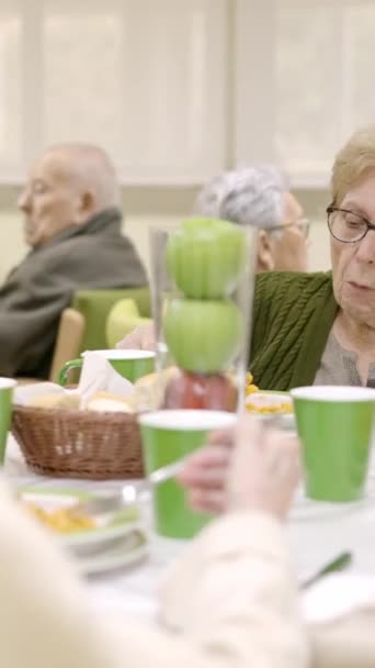 Zpomalené video skupiny starších žen jíst a mluvit sedí v geriatrics jídelně - Záběry, video
