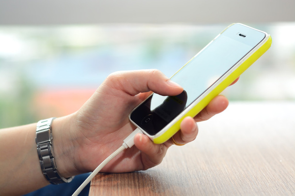 Puhelimen lataaminen energiapankilla ja älypuhelimen käyttö käsissä
 - Valokuva, kuva