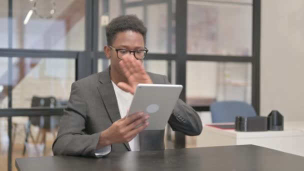 афроамериканський чоловік робить відео чат на планшеті в офісі - Кадри, відео