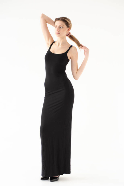 schöne junge Frau in schwarzem Kleid isoliert auf weißem Hintergrund - Foto, Bild