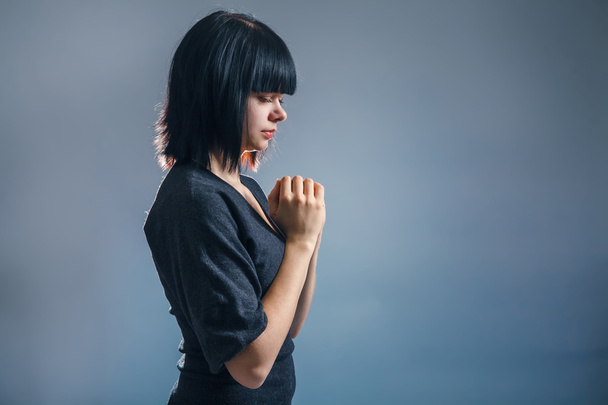 European appearance brunette girl clasped her hands in prayer on - Foto, Imagem