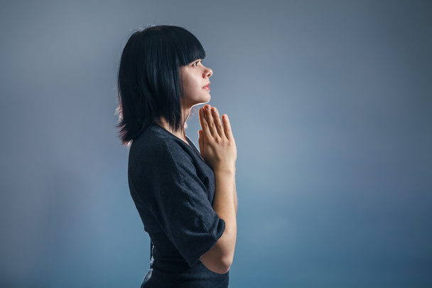 Aspect européen fille brune serra les mains dans la prière sur
 - Photo, image