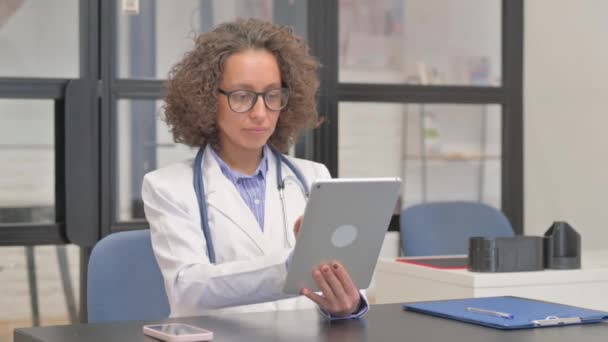 Latynoska lekarka pracująca nad tabletką cyfrową w szpitalu - Materiał filmowy, wideo