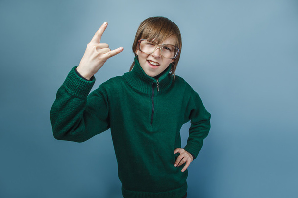 chico de aspecto europeo de diez años mostrando pulgares hacia arriba en un gris
 - Foto, imagen