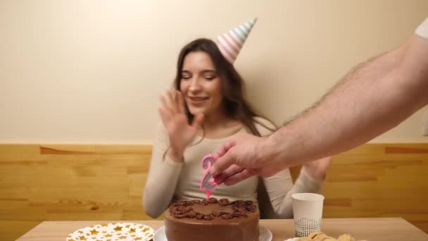 Dívka sedí před stolem se slavnostním dortem, do kterého se zasekla svíčka v podobě čísla26. Koncept oslavy narozenin. - Záběry, video