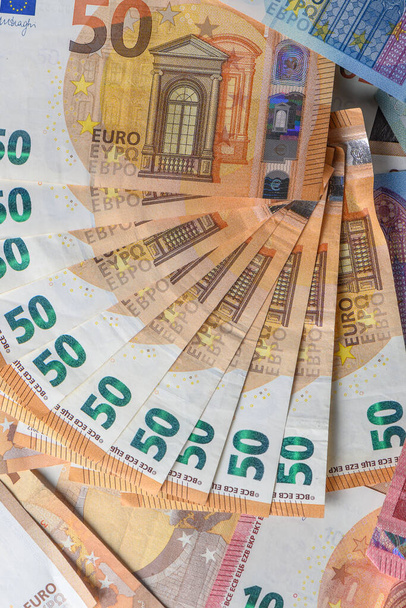 Cinquanta banconote in euro, disposte a ventaglio, sullo sfondo monetario 7 - Foto, immagini