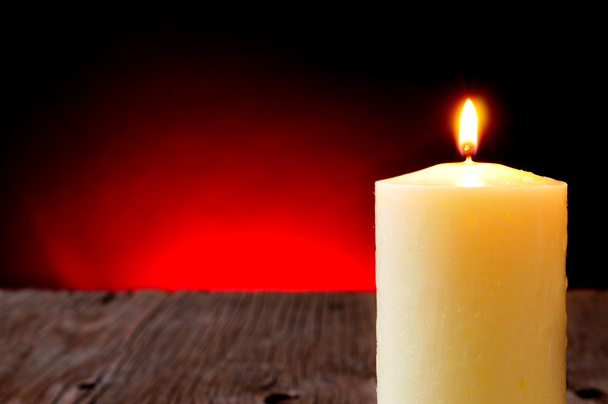 Kerze auf rustikalem Holztisch angezündet - Foto, Bild