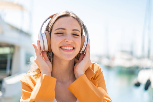 Joven bonita mujer al aire libre escuchando música - Foto, Imagen