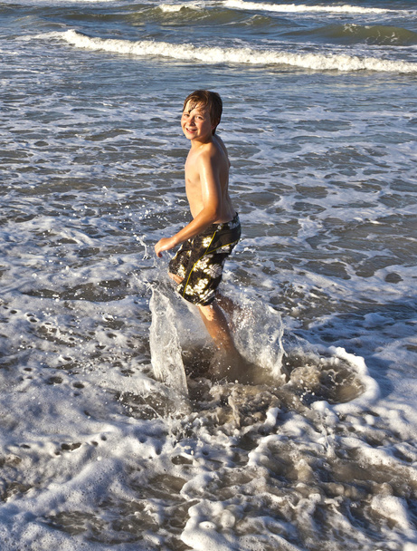 kleiner glücklicher Junge genießt die Wellen des blauen Meeres - Foto, Bild