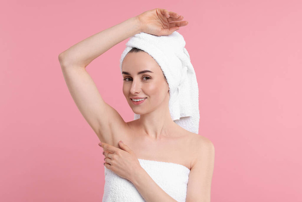 Beautiful woman showing armpit with smooth clean skin on pink background - Photo, Image