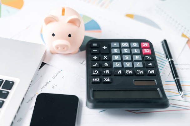Piggy bank with business stuff, business and finance concept. calculators on financial statements, business chart showing financial success at the stock market - Photo, Image