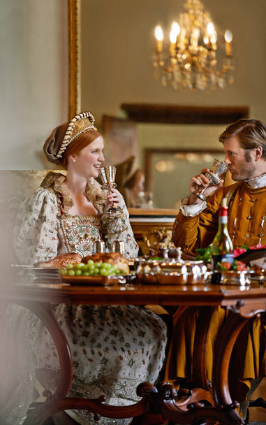 Királynő, király és pár bor, boldog és pihenni együtt vacsora, ünneplés vagy party királyi palotában. Nő, férfi és mosoly üveggel, alkohollal vagy étellel a viktoriánus palotában. - Fotó, kép