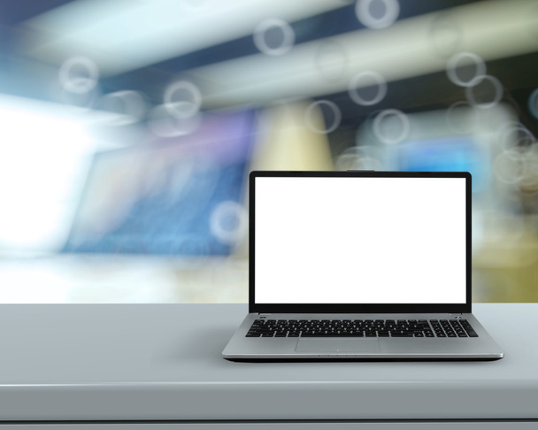 Ordenador portátil con pantalla en blanco en escritorio blanco con fondo borroso a
 - Foto, Imagen