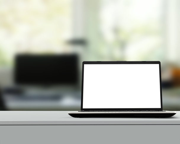 Notebook s prázdnou obrazovkou na bílém stole s rozmazané pozadí - Fotografie, Obrázek