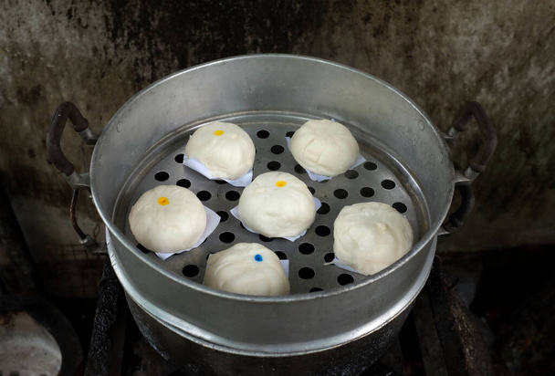 close up a homemade of steamed buns ( Chinese steamed buns ) ,stuffed steamed bun with pork filling, cream, sweet, red pork ,red beansin the steam pot . it taste delicious and suitable for breakfast.  - Photo, Image