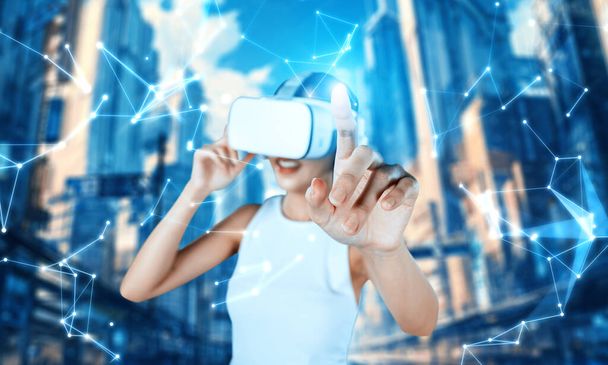 Stojak damski nosi białe słuchawki VR i białe bezrękawkowe połączenie metawersum, przyszła technologia tworzy społeczność cyberprzestrzeni. Używa palca wskazującego hologram obiektu wirtualnej rzeczywistości. omamy. - Zdjęcie, obraz