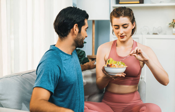 Healthy sporty and vegetarian couple in sportswear with a bowl of fruit and vegetable. Healthy cuisine nutrition and vegan lifestyle for fitness body physique at gaiety home concept. - Photo, Image