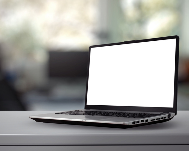 Ноутбук с чистым экраном на белом столе с размытым фоном
 - Фото, изображение