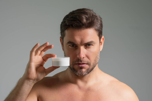 Handsome aged man applying face cream. Beauty routine. Man with perfect skin. Anti-aging and wrinkle cream. Concept of male beauty. Close up face of man applying cream to skin. Skincare and cosmetics - Zdjęcie, obraz