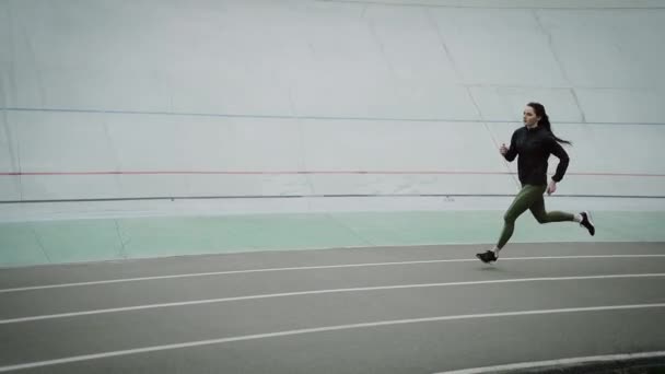 Sportos lány fut és edz a stadionban. - Felvétel, videó