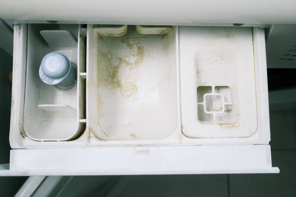 Likainen pesukone. Musta hometta, kalkkipitoinen lika pesukoneessa, jossa on avoin annostelulaatikko pyykin jälkeen. Kodinkoneiden hoito ja siivous - Valokuva, kuva