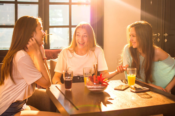 Nuoret naiset puhuvat ja hauskaa kahvilassa - Valokuva, kuva