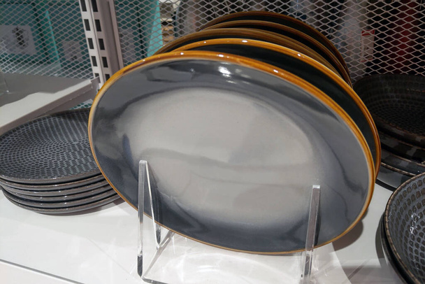 Ein Stapel weißer Teller, fein säuberlich auf einer Küchentheke angeordnet, schafft eine einfache und praktische Aufbewahrungslösung für Geschirr. Die Platten sind sauber, glänzend und gebrauchsfertig. - Foto, Bild
