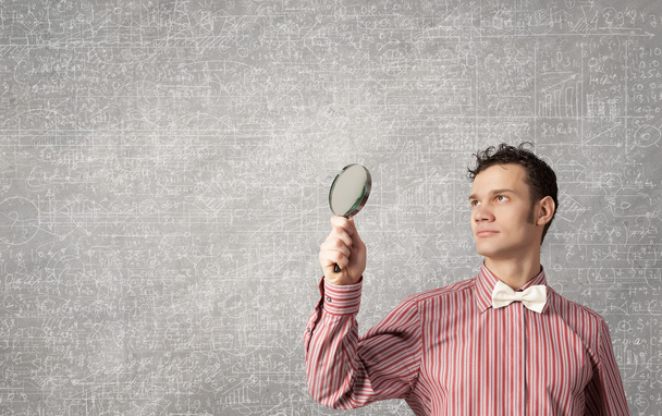 Guy looking in magnifying glass - Photo, image