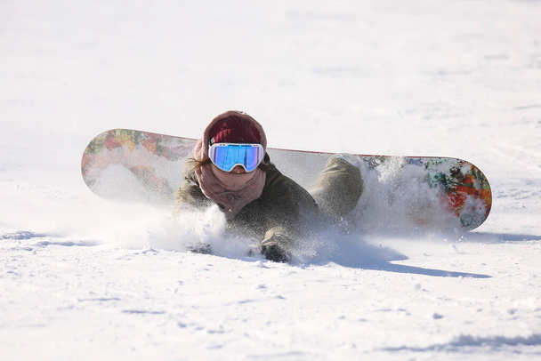 Жінка сноубордистка падає - Фото, зображення