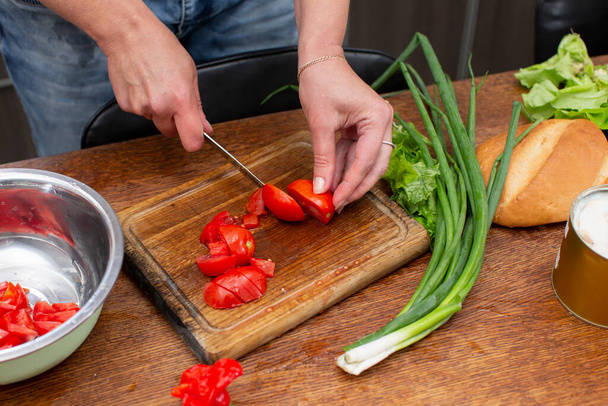 Posiekać zieloną cebulę i pomidory i umieścić je w misce. Przygotuj sałatkę.. - Zdjęcie, obraz