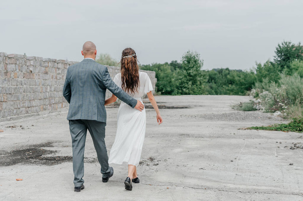 η νύφη και ο γαμπρός περπατούν στο δρόμο - Φωτογραφία, εικόνα