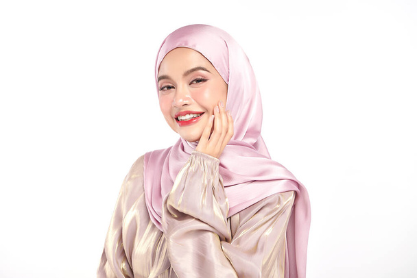 Kaunis nuori aasialainen musliminainen yllään vaaleanpunainen hijabi valkoisella taustalla, arabien kauneuden muotokuva. - Valokuva, kuva